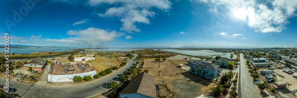Fototapeta Aerial panorama view of Alviso district in San Jose California with rundown buildings colorful orange, yellow salt marshes in the Bay Area