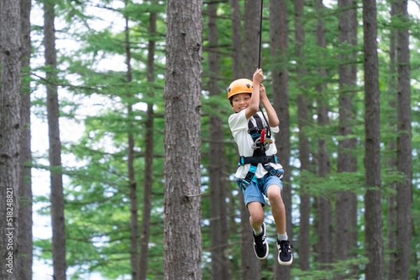 Fototapeta 夏休みにジップラインで遊ぶアジア人の小学生