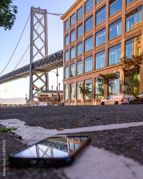Obraz bay bridge reflection on smart phone in the city