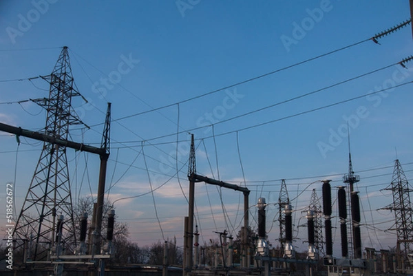Fototapeta Powerful urban electrical substation with transformers and power lines.