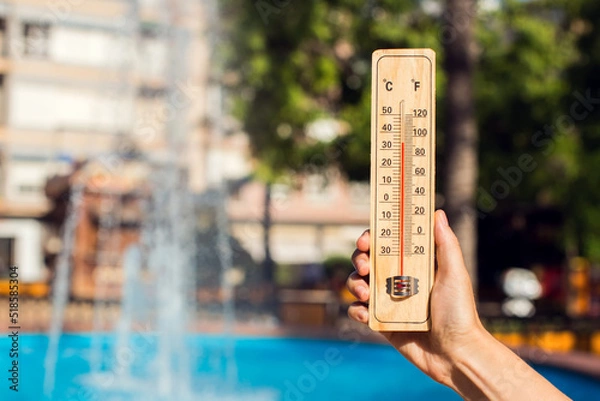 Fototapeta Hot weather. Thermometer in front of fountain during heatwave.