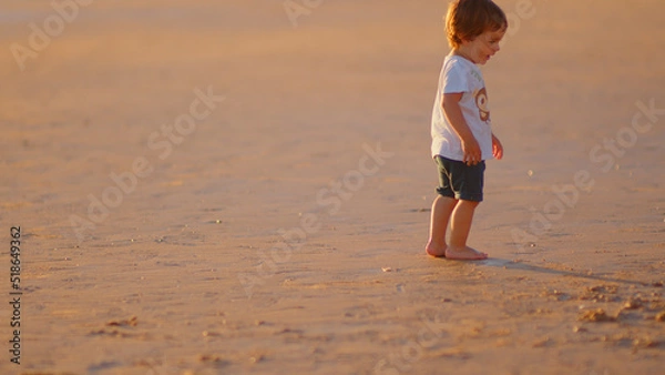 Fototapeta Wonderful family - father, mother and 4 sons (1-8 years old) - walk along one of the most beautiful beaches of Cádiz at sunset - they love and hug each other, look after their children