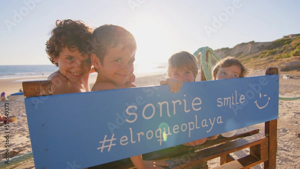 Fototapeta Wonderful family - father, mother and 4 sons (1-8 years old) - walk along one of the most beautiful beaches of Cádiz at sunset - they love and hug each other, look after their children
