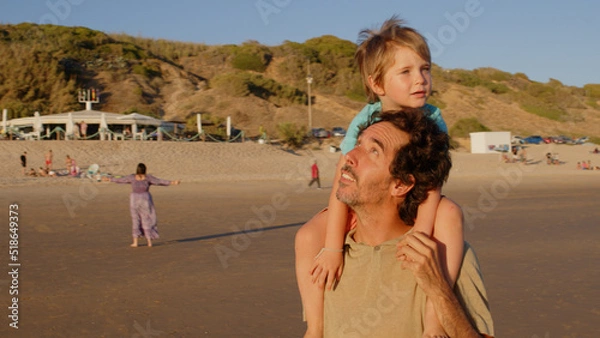 Fototapeta Wonderful family - father, mother and 4 sons (1-8 years old) - walk along one of the most beautiful beaches of Cádiz at sunset - they love and hug each other, look after their children