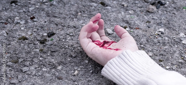Obraz a man's hand is covered in blood lying on the asphalt on the road