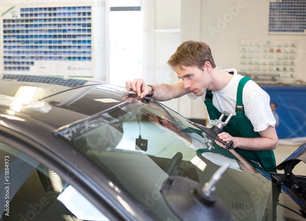 Obraz Worker in glazier's workshop installs windshield