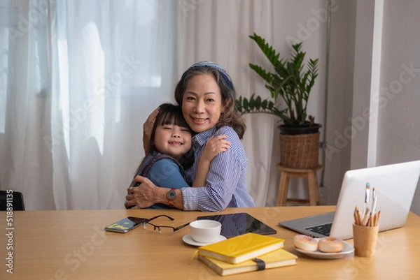 Fototapeta Portrait of an elderly woman and granddaughter hugging each other to show affection and family activities.