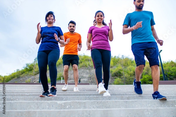 Fototapeta four indian people warming up outdoors in sport wear morning time urban