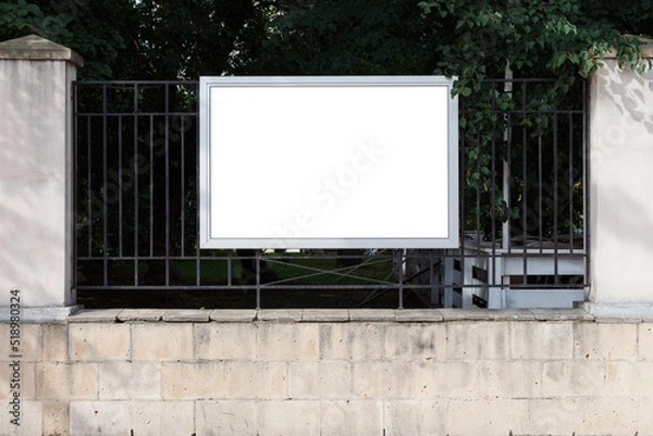 Fototapeta Horizontal rectangular billboard on the fence of the park. Mock-up.