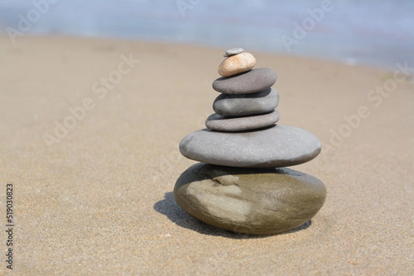 Obraz Stack of stones on sandy beach near sea, space for text