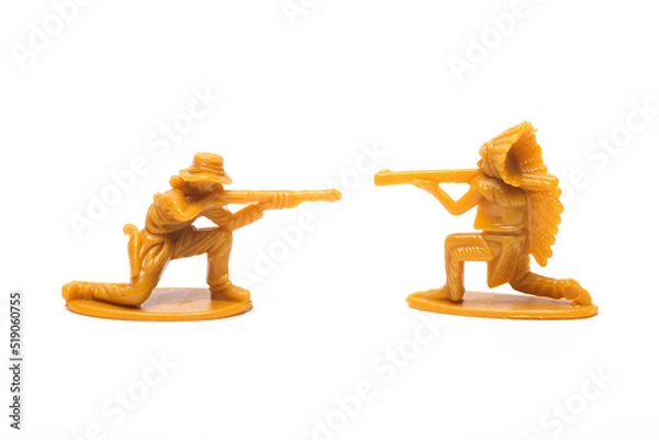 Fototapeta Wild West. Plastic figurines of a cowboy and a native american with guns exchange fire on white background
