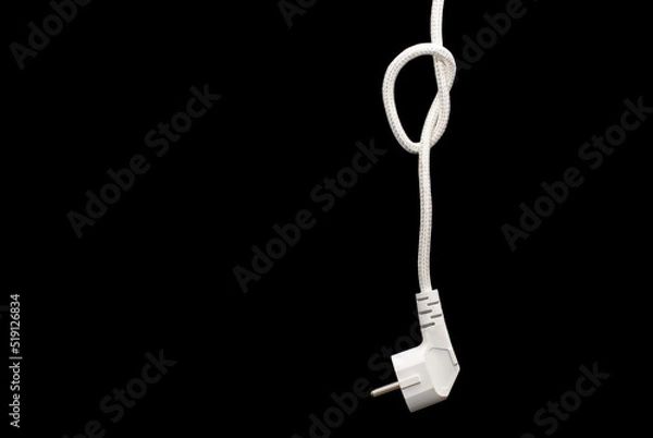 Fototapeta Electric plug for a socket with a knot on a cable on a black background with free space for text. The concept of the inability to get energy or electricity. No access to electricity or power outages