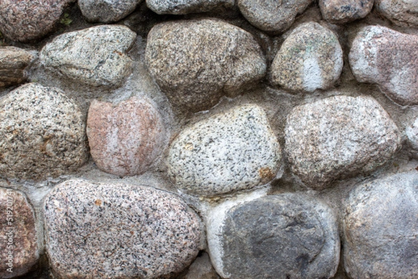 Fototapeta Handmade stone masonry of oval stones. Textured background of large stones. Ancient wall of large stones, military fortification. An abstract texture of wall. Masonry stone arbitrary shape.