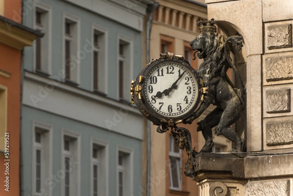 Obraz Zegar z lwem na tle kamienic.