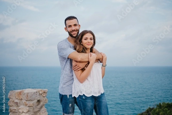 Obraz A man is hugging his girlfriend in the highland park near the sea in Spain