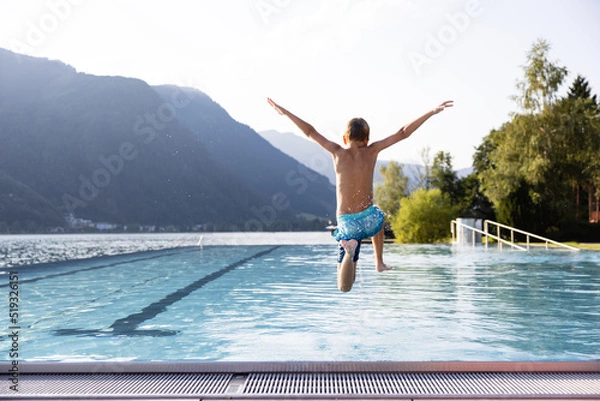Obraz Active teenager boy jumping into an outdoor pool in the Alps. Summer holiday concept