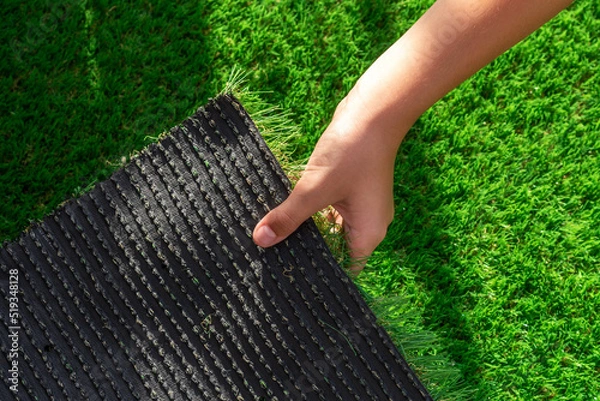 Fototapeta Close-up of the back of a roll of artificial turf. Synthetic artificial grass material easy to install and maintain