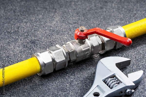 Obraz Gas tap connected to yellow gas pipe and wrench. Concept repairing gas pipeline