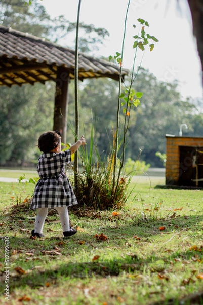 Fototapeta Cute baby girl poiting finger and walking. Aesthetic baby. Child development.