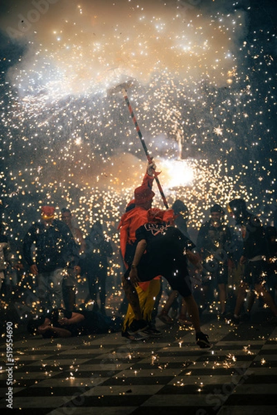 Fototapeta correfoc canovelles, people dancing around devil carrying fireworks in catalonia spain