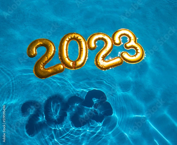 Fototapeta figures 2023 new year float in the blue pool in splashes of water