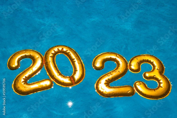 Fototapeta figures 2023 new year float in the blue pool in splashes of water