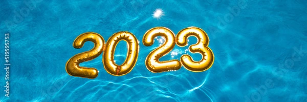 Fototapeta banner figures 2023 new year float in the blue pool in splashes of water