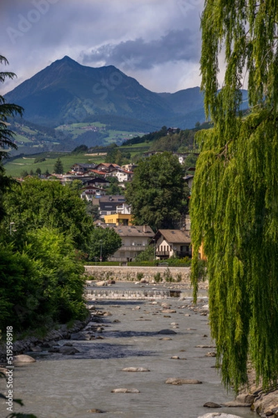 Obraz The upright landscape of Bressanone Brixen. The iconic town view with the river, houses, waterfall, mountains and sky.
