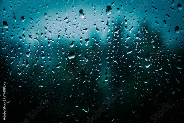 Fototapeta Drops of rain on glass with filter effect retro vintage style. Raindrops on window glass. Selective focus. Rainy city background. Wet glass view of park autumn, abstract background drops on the glass.