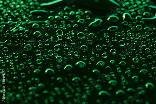 Fototapeta Beautiful macro photo of water drop reflection, lying on surface, front view. Close up of liquid with side lighting from displays.