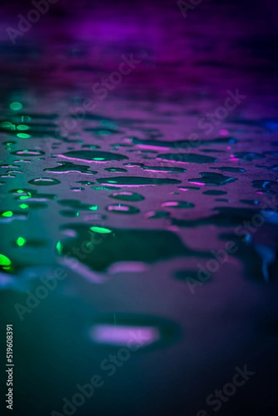 Fototapeta Beautiful macro photo of water drop reflection, lying on surface, front view. Close up of liquid with side lighting from displays.