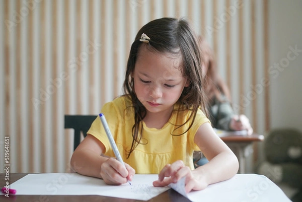 Fototapeta Preschool kids drawing with color pencil on white paper on table in classroom with friends, kindergarten education concept