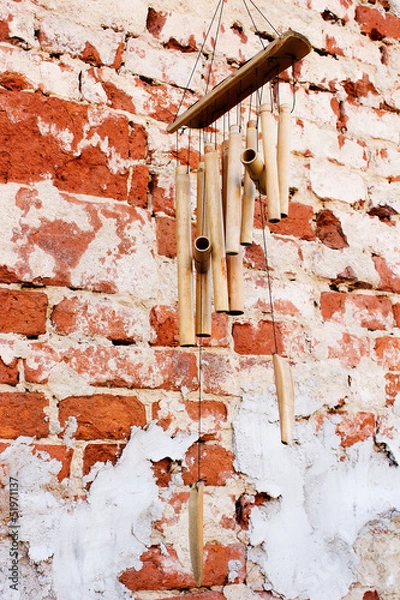 Obraz Bamboo wind chimes on the brick wall background