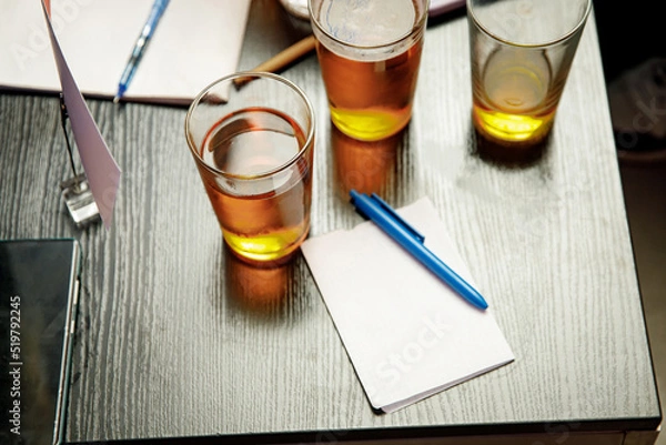 Fototapeta The pub quiz concept. Beer glass and blank paper for answers.