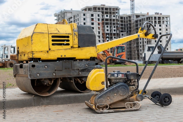 Fototapeta Vibratory rammer with vibrating plate on a construction site. Manual roller. Compaction of the soil before laying paving slabs. close-up.