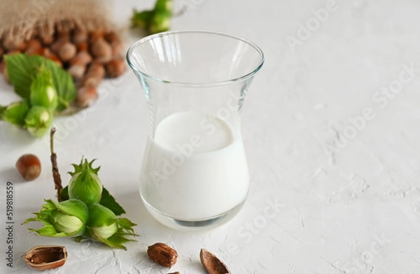 Fototapeta Hazelnut non dairy milk and hazelnuts . This milk is an excellent source of antioxidants, phytosterols and heart-healthy fats and supports and improves the elasticity of vascular walls