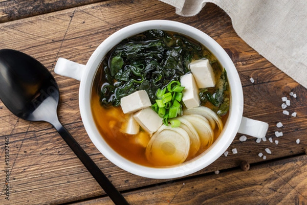 Fototapeta Japanese miso soup in a white bowl on the table. Horizontal view from above