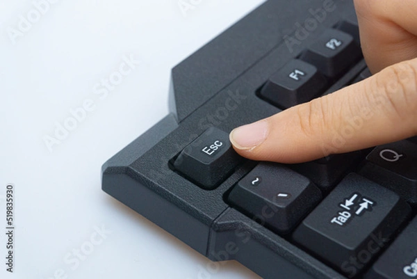 Fototapeta A woman's finger holding a computer keyboard