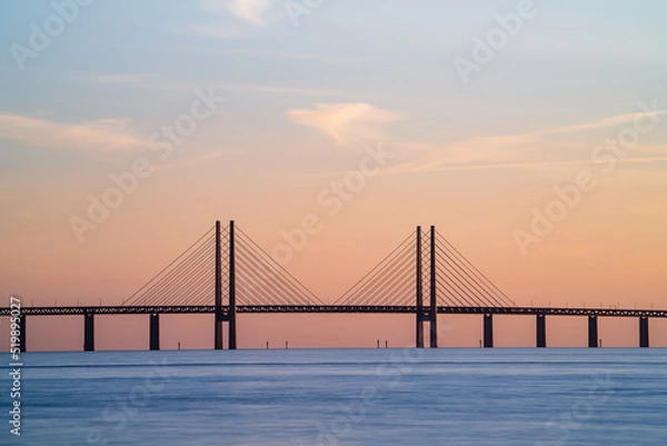 Obraz The Oresund Bridge is a combined motorway and railway bridge between Sweden and Denmark (Malmo and Copenhagen). Long exposure. Selective focus.