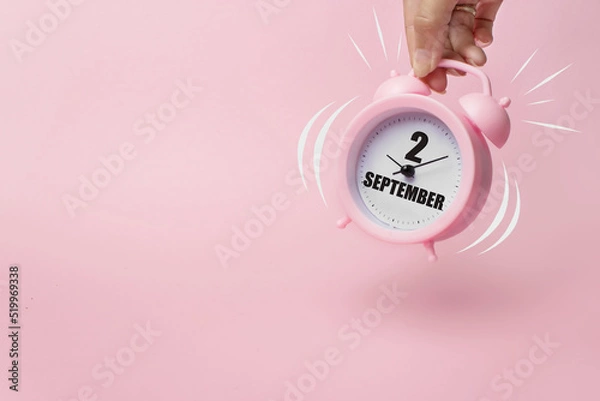 Fototapeta September 2nd. Day 2 of month, Calendar date. The morning alarm clock jumping up from the bell with calendar date on a pink background. Autumn month, day of the year concept.