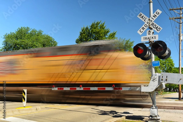 Obraz Freight train in motion speeding at crossing gate