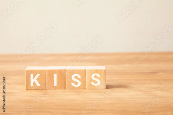 Obraz KISSの文字。キス。簡略化。Keep It Simple, Stupid。4つの木製ブロックに書かれている。白い背景。