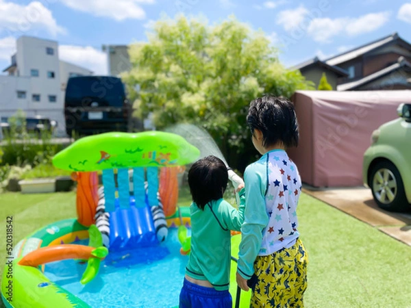 Fototapeta 庭でプールで遊ぶ日本人の子供