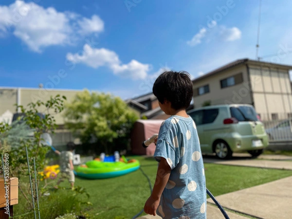 Fototapeta 庭で水をまいて遊ぶ日本人の子供