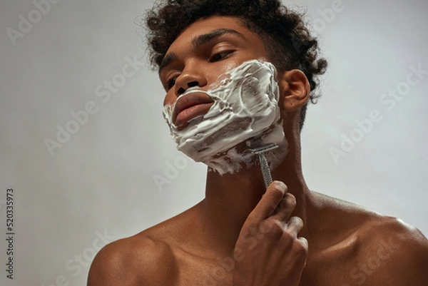 Obraz Cropped of guy shaving razor with shaving foam