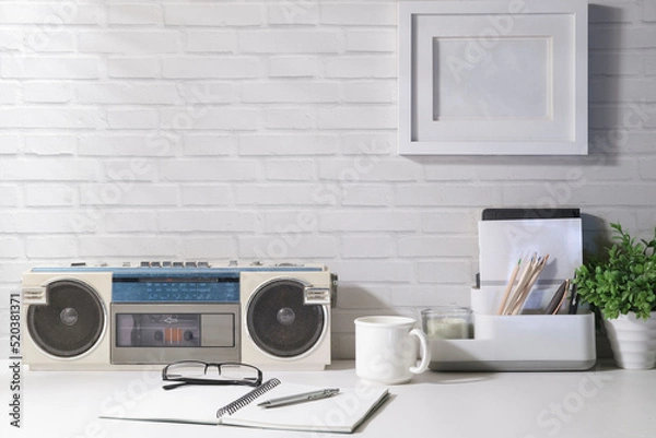 Obraz Vintage radio, coffee cup, notebook and potted plant on white table with daylight from the window. Copy space for advertise text.