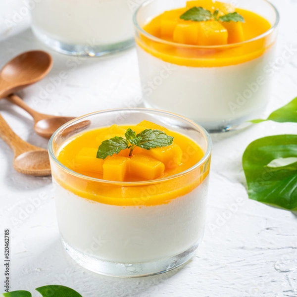 Fototapeta Delicious double colored mango panna cotta mousse pudding on white table background.