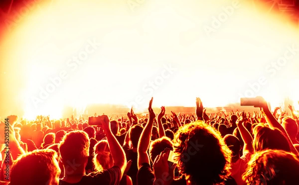 Fototapeta crowd of people at rock concert in front of bright stage lights