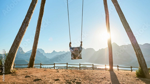 Fototapeta Man swinging on a giant wooden swing. Biggest swing of Leon in Riaño, in the nature.