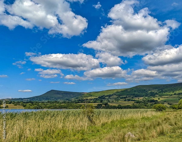 Obraz Clouds over lake with hilly backdrop